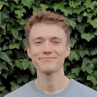 Robert Bogle, smiling, in front of an ivy wall